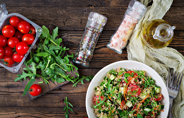 Salads with quinoa, arugula, radish, tomatoes and cucumber in bowl - Stock Photo - Images