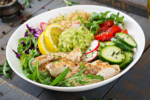Buddha bowl lunch with grilled chicken and quinoa, tomato, guacamole, red cabbage, cucumber - Stock Photo - Images