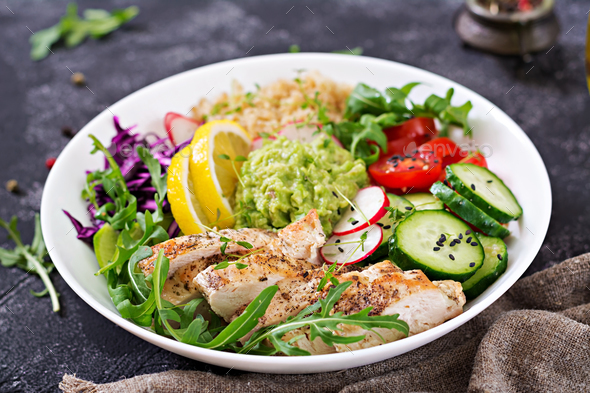 Buddha bowl lunch with grilled chicken and quinoa, tomato, guacamole, red cabbage, cucumber - Stock Photo - Images
