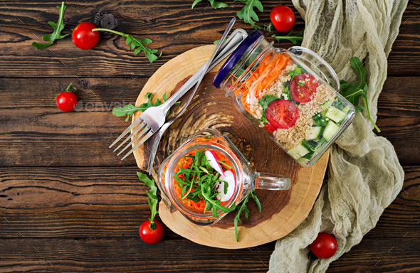 Salads with quinoa, arugula, radish, tomatoes and cucumber in glass jars - Stock Photo - Images