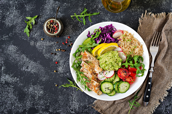 Buddha bowl lunch with grilled chicken and quinoa, tomato, guacamole, red cabbage, cucumber - Stock Photo - Images