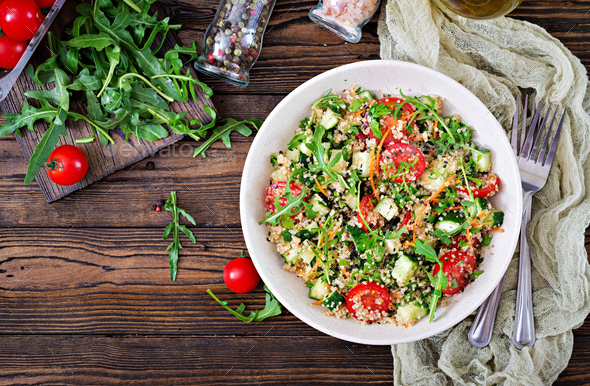 Salads with quinoa, arugula, radish, tomatoes and cucumber in bowl - Stock Photo - Images