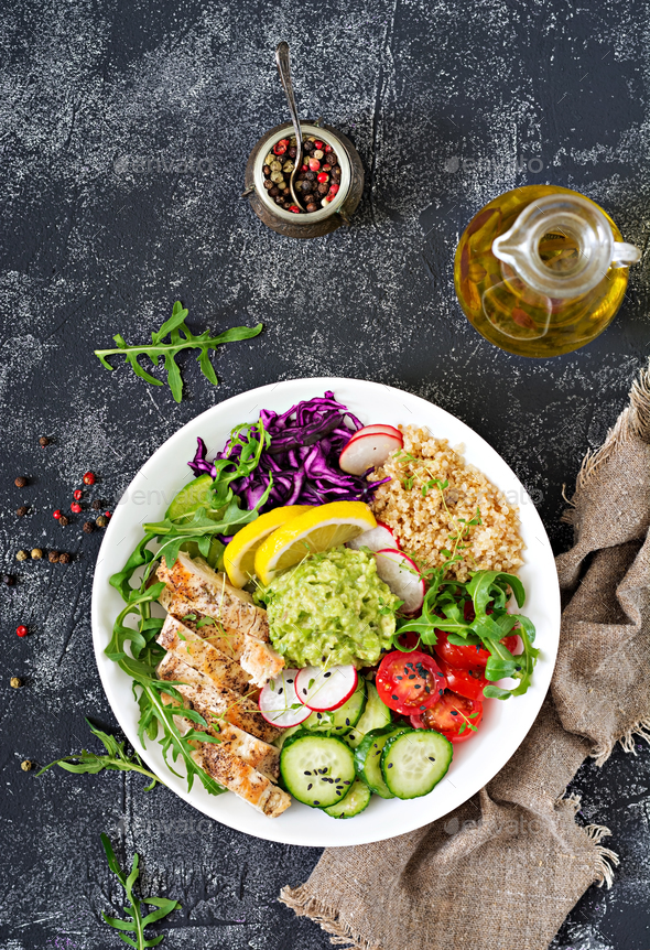 Buddha bowl lunch with grilled chicken and quinoa, tomato, guacamole, red cabbage, cucumber - Stock Photo - Images