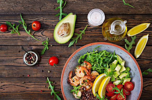 Buddha bowl with shrimps, tomato, avocado, quinoa, lemon and arugula - Stock Photo - Images