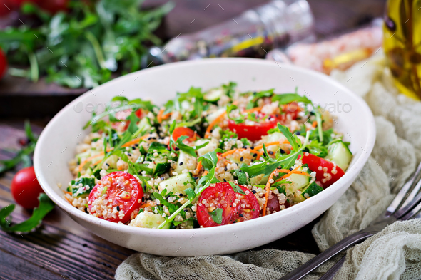 Salads with quinoa, arugula, radish, tomatoes and cucumber in bowl - Stock Photo - Images