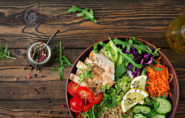 Buddha bowl lunch with grilled chicken and quinoa, tomato, guacamole, carrot, red cabbage, cucumber - Stock Photo - Images