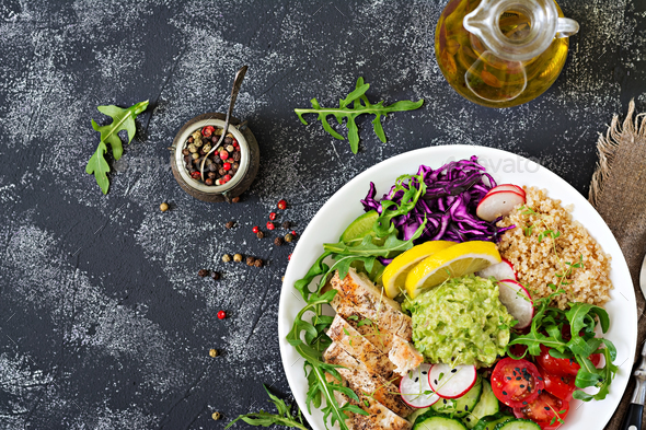 Buddha bowl lunch with grilled chicken and quinoa, tomato, guacamole, red cabbage, cucumber - Stock Photo - Images