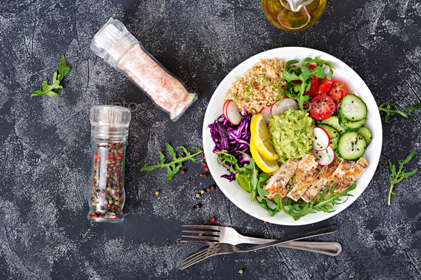 Buddha bowl lunch with grilled chicken and quinoa, tomato, guacamole, red cabbage, cucumber - Stock Photo - Images