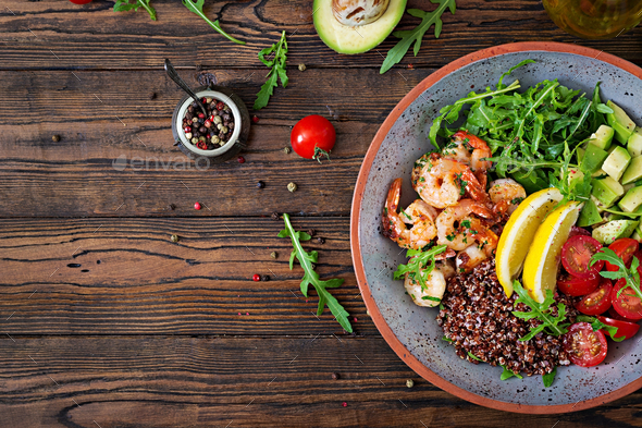 Buddha bowl with shrimps, tomato, avocado, quinoa, lemon and arugula - Stock Photo - Images