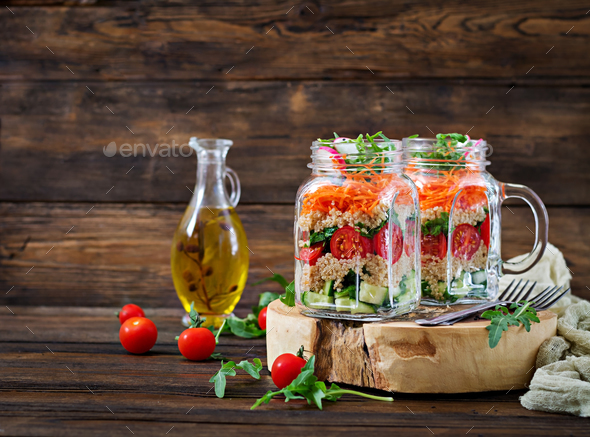 Salads with quinoa, arugula, radish, tomatoes and cucumber in glass jars - Stock Photo - Images