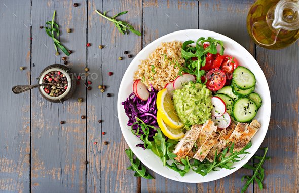 Buddha bowl lunch with grilled chicken and quinoa, tomato, guacamole, carrot, red cabbage, cucumber - Stock Photo - Images