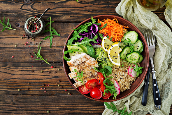 Buddha bowl lunch with grilled chicken and quinoa, tomato, guacamole, carrot, red cabbage, cucumber - Stock Photo - Images