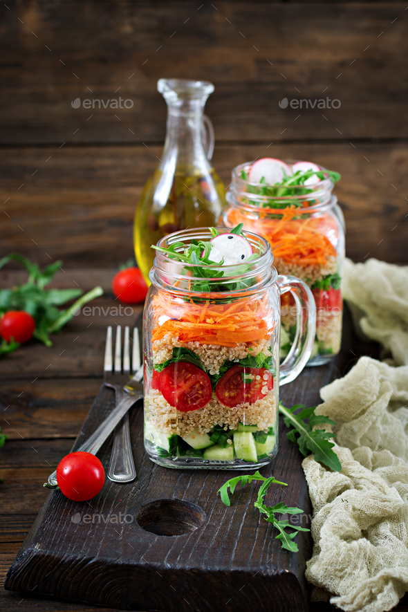 Salads with quinoa, arugula, radish, tomatoes and cucumber in glass jars - Stock Photo - Images