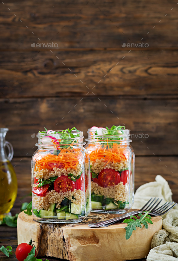 Salads with quinoa, arugula, radish, tomatoes and cucumber in glass jars - Stock Photo - Images