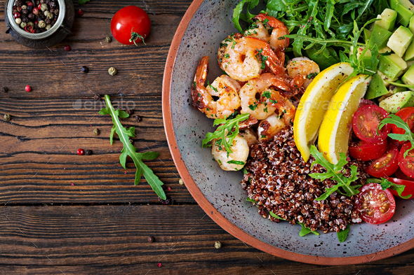 Buddha bowl with shrimps, tomato, avocado, quinoa, lemon and arugula - Stock Photo - Images