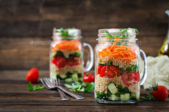 Salads with quinoa, arugula, radish, tomatoes and cucumber in glass jars - Stock Photo - Images