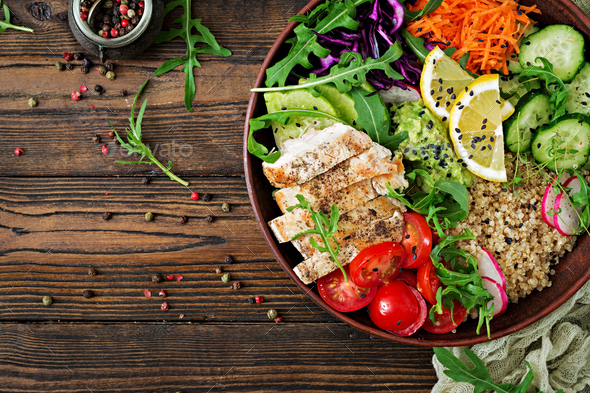 Buddha bowl lunch with grilled chicken and quinoa, tomato, guacamole, carrot, red cabbage, cucumber - Stock Photo - Images