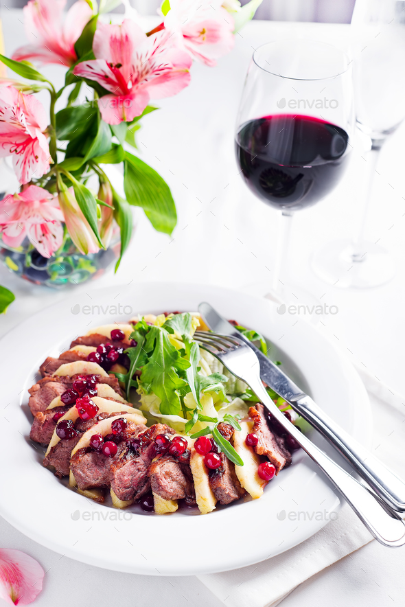 Salad with slices of duck breast with apples and salad under cowberry sauce - Stock Photo - Images