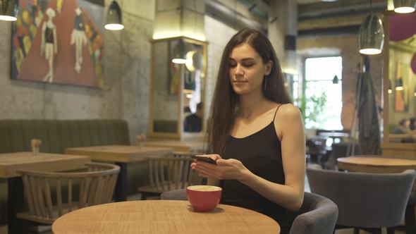 Woman Blogger with Smartphone in Restaurant