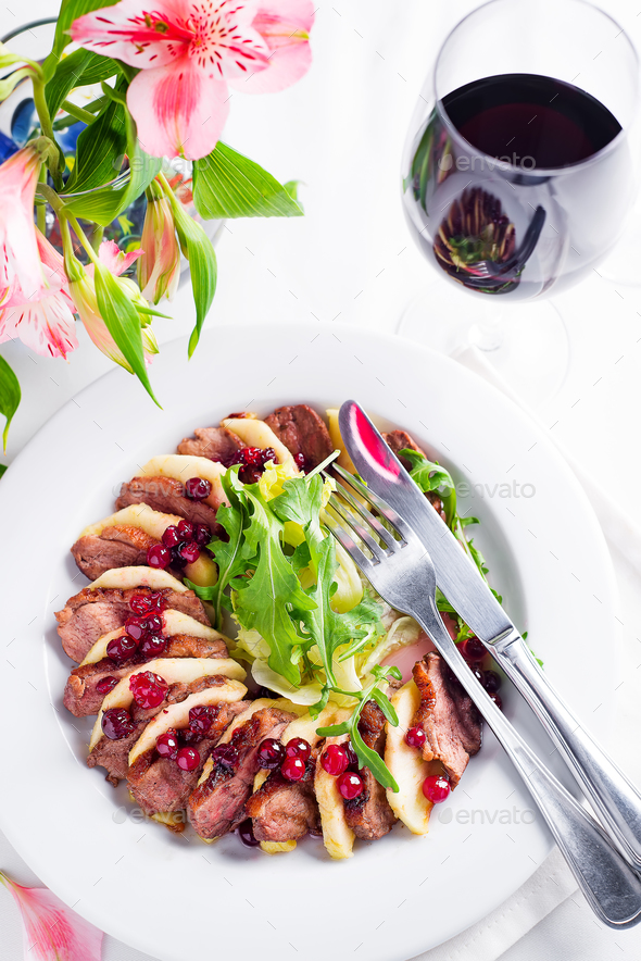 Salad with slices of duck breast with apples and salad under cowberry sauce - Stock Photo - Images