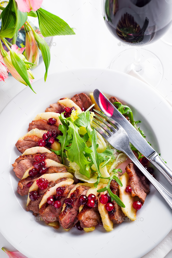 Salad with slices of duck breast with apples and salad under cowberry sauce - Stock Photo - Images