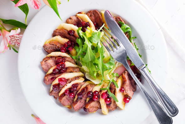 Salad with slices of duck breast with apples and salad under cowberry sauce - Stock Photo - Images