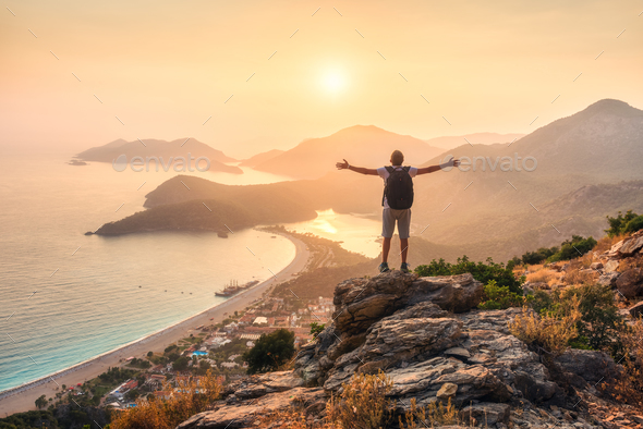 Young sporty man with backpack, seashore and mountains - Stock Photo - Images