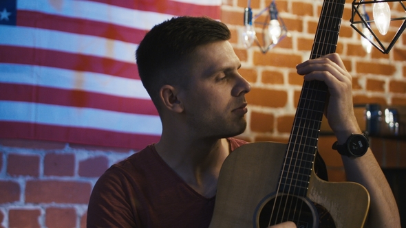 Handsome Young Guitarist Looking at Camera alt