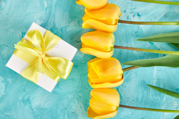 Gift box with yellow ribbon near tulip - Stock Photo - Images