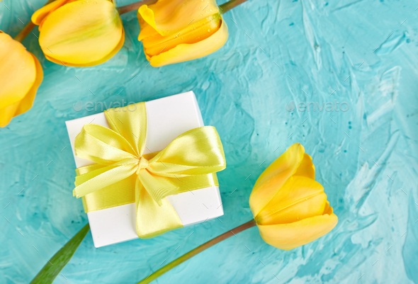 Gift box with yellow ribbon near tulip - Stock Photo - Images