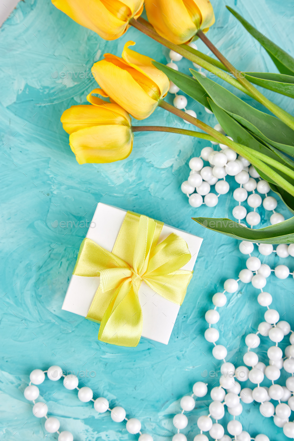Gift box with yellow ribbon near tulip - Stock Photo - Images