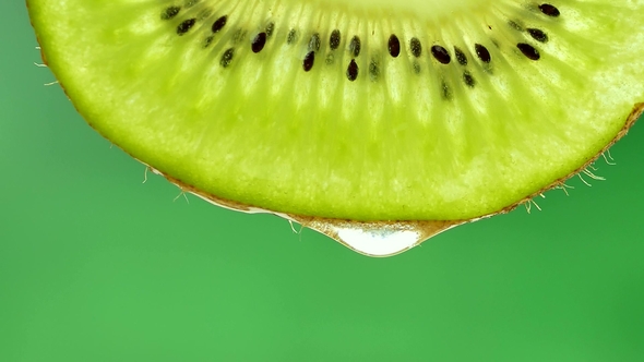 Drop of Pure Water or Juice Dripping From a Slice of Kiwi