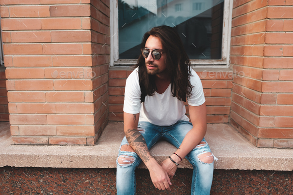 Portrait attractive man near window on urban background - Stock Photo - Images