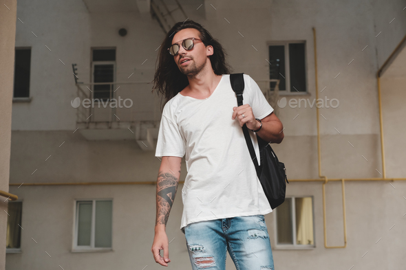 Man on urban background with backpack and sunglasses - Stock Photo - Images
