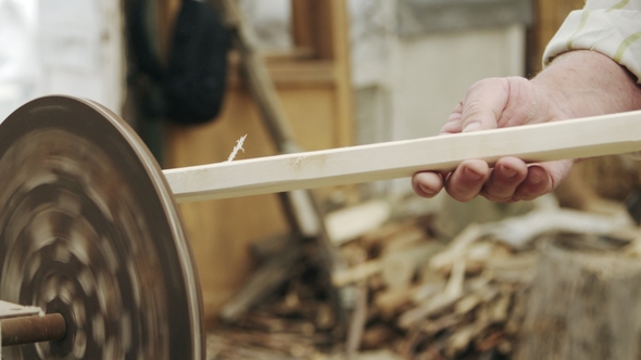 Elderly Man Carpenter Builds a Small Boat with His Hands Out of Wood in a Small Workshop alt