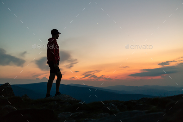 Man celebrating sunset looking at view in mountains Stock Photo by blas