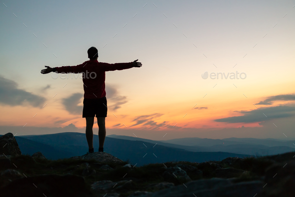 Man celebrating sunset looking at view in mountains Stock Photo by blas