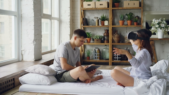 Loving Couple Is Enjoying Augmented Reality Glasses Woman Is Wearing Them Moving Arms and Body While alt