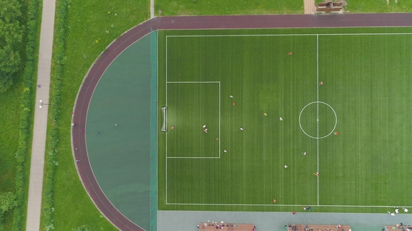 Green Soccer Field Players Playing Football Aerial Vertical Top-Down View Flying Sideways alt