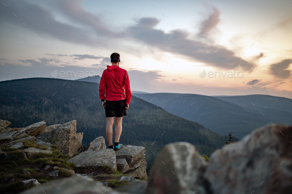 Man celebrating sunset looking at view in mountains - Stock Photo - Images