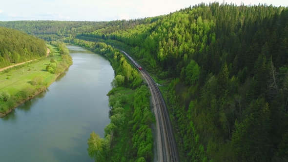 Flying Back Over Passing Train. River and Green Forest. Aerial View alt