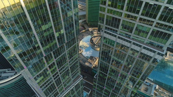 Flying Up Between Two Modern Tall Skyscrapers with Offices and Apartments in Morning. Aerial View alt