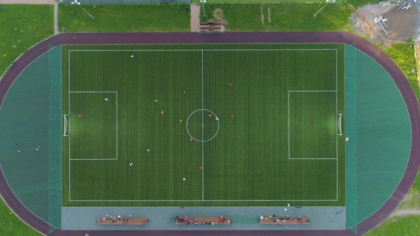 Green Soccer Field. Players Playing Football. Aerial Vertical Top-Down