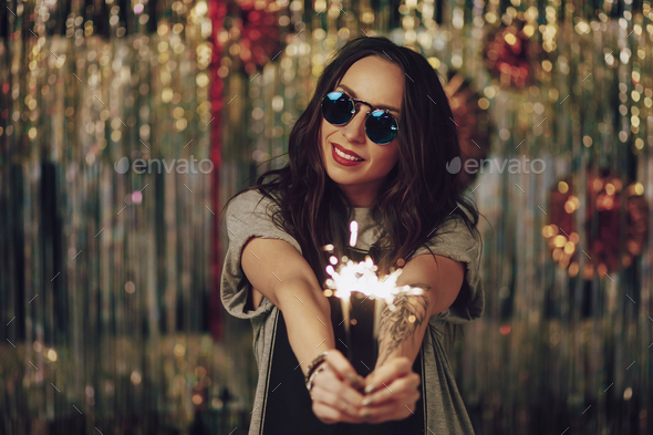 Attractive hipster girl holding sparklers in hands - Stock Photo - Images
