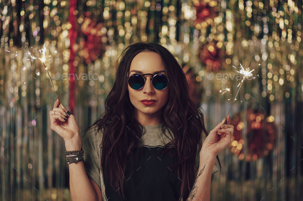 Attractive hipster girl holding sparklers in hands - Stock Photo - Images