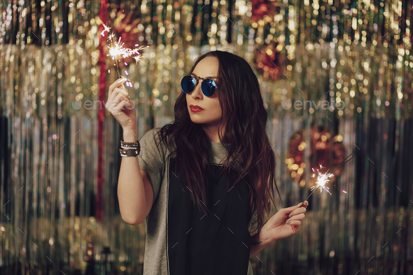 Attractive hipster girl holding sparklers in hands - Stock Photo - Images