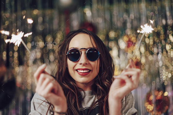 Beautiful girl holding sparklers in hands - Stock Photo - Images