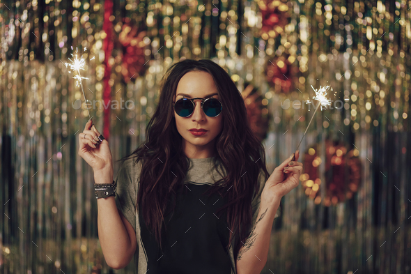 Attractive hipster girl holding sparklers in hands - Stock Photo - Images