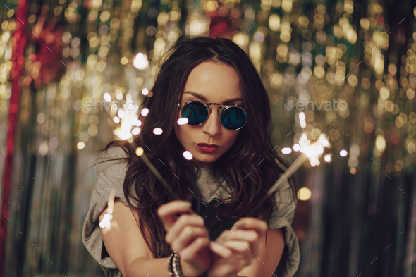 Attractive hipster girl holding sparklers in hands - Stock Photo - Images