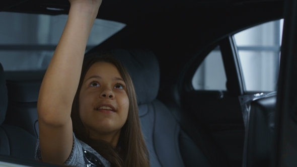 Teenage Girl Sitting in New Car alt